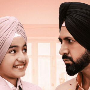 Father and son wearing turbans smiling at each other in a heartwarming scene from the movie 'Shinda Shinda No Papa'."