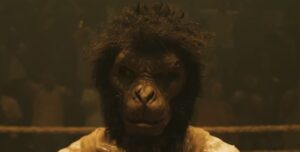 A character, dressed in a realistic monkey mask, stands in a dark fighting arena, with an atmosphere that feels primal and fierce.