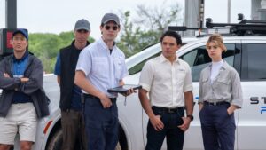 A group of five storm researchers from the movie Twisters, standing beside their storm-chasing vehicle, equipped with advanced meteorological gear, showing a focused and prepared demeanor, ready for storm tracking.