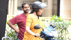 Intense scooter scene from Sharmajee Ki Beti with a woman driving and a man looking back, hinting at a pursuit or escape.