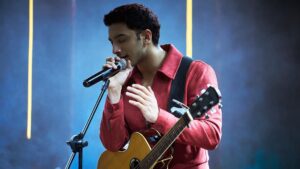 A man singing on stage in Jigra, showcasing his musical talent.