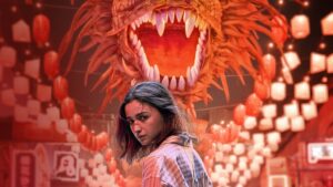 A woman standing in front of a fierce dragon, setting the tone for the suspenseful movie Jigra.