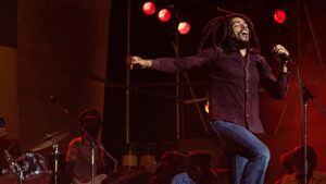 Bob Marley in powerful moments from the movie Bob Marley: One Love, showcasing his music, family, and legacy.