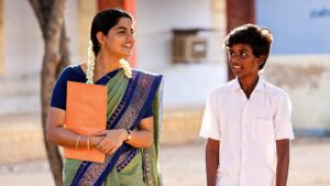 Teacher and young boy Thambi sharing a moment in the Tamil movie Vaazhai, showcasing village life and human connections.