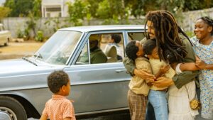  "Bob Marley hugging children in a heartwarming scene from Bob Marley: One Love."