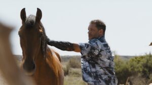 Eddie Brock controls a horse using Venom's symbiote powers in a striking scene from Venom: The Last Dance.
