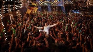 A vibrant crowd celebrating during a festival scene in Avashman, highlighting the film's energetic atmosphere.