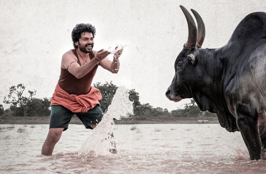 Scene from the movie Meiyazhagan (2024), featuring the protagonist facing a large black bull in a rural setting, symbolizing themes of strength and heritage.