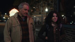 Two characters from Ghostlight 2024 walking on a dimly lit street, looking concerned.