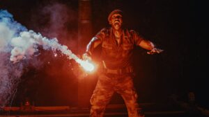 Military character holding a flare in Jurassic World Rebirth during a thrilling night scene