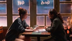 main two characters seating on table and communicate with each other  the movie "Do Patti"